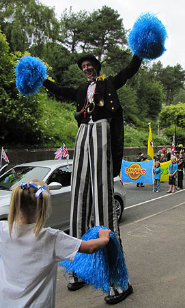 Stilt man with pom-poms