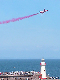 Red Arrow Hawk above West pier lighthouse