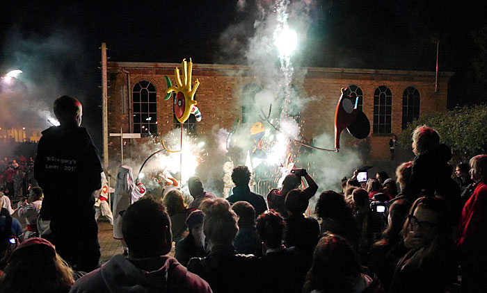 crowd illuminated by fireworks