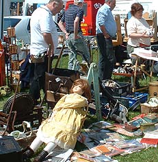 Customers peruse a car boot stall
